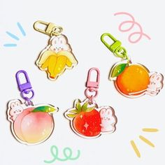 four different colored apple charms on a white background with the words hello kitty written below them