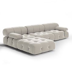 a white couch sitting on top of a white floor next to a chair and ottoman