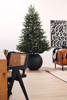 a living room with a christmas tree in the corner and leather chairs on the floor