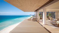 an ocean view from the balcony of a beachfront home with chairs and couches