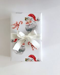 a present wrapped in white paper with santa claus on it