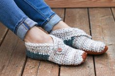 a woman's feet wearing slippers and jeans