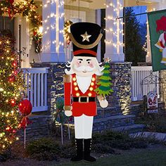 a large christmas nutcracker in front of a house decorated with lights and garlands