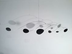 a group of black and white circles hanging from a ceiling fixture in an empty room