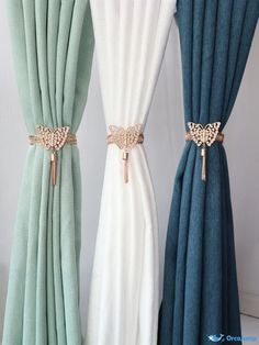 three different colored curtains with gold hardware on them