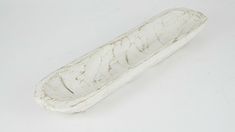 an old white wooden object on a white surface