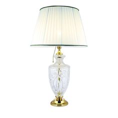 a glass lamp with a gold base and shade on it's side, against a white background