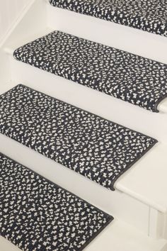 the stair treads are decorated with black and white floral fabric, along with matching rugs