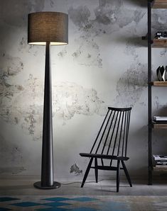 a black chair sitting next to a lamp in a room