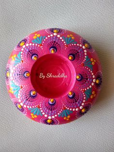 a pink bowl with colorful designs on the bottom and words by shraddhya