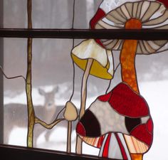 a close up of a stained glass window with animals in the background and snow on the ground