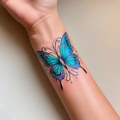 a woman's arm with a blue butterfly tattoo on it