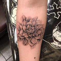 a black and white flower tattoo on the arm