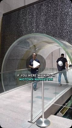 two men standing on an escalator in front of a building with the words if you were walking through midtown ave