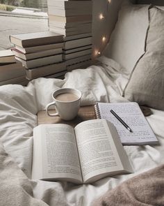 a cup of coffee and some books on a bed