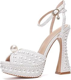 a white high heeled shoe with pearls