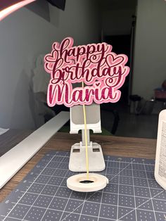 a pink happy birthday sign sitting on top of a table