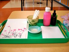 a green tray with pink flowers on it and some white napkins in the middle