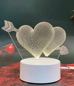 a white heart shaped lamp on top of a table