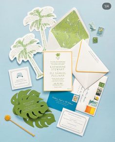 the wedding stationery is laid out on top of each other, including palm trees and envelopes