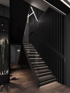 a staircase leading up to the second floor in a modern house with black walls and wooden floors