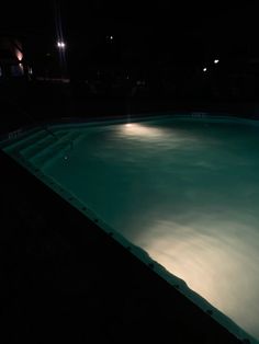 an empty swimming pool lit up at night