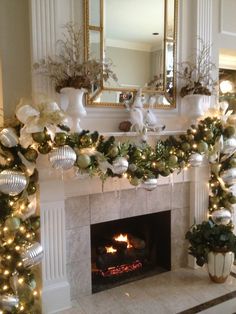 a fireplace decorated for christmas with ornaments and lights