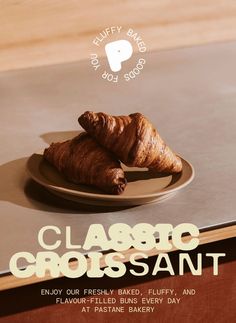 two croissants sitting on a plate with the words classic croissant