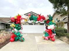 an arch made out of balloons and candy canes in front of a house with a garage