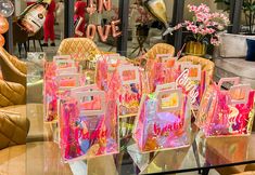 there are many bags on the table in this store display case, and one is filled with candy