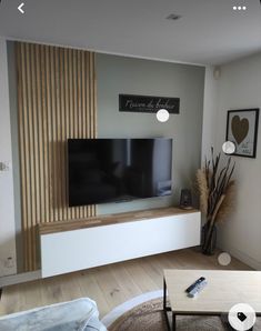 a flat screen tv sitting on top of a white entertainment center in a living room