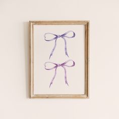 a framed painting with a purple bow hanging on the wall