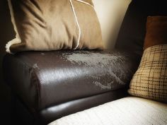 a brown leather chair with two pillows on it