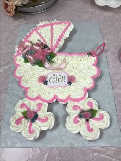 a cake shaped like a baby carriage with pink trimmings and flowers on it