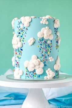 a blue cake with white frosting and sprinkles