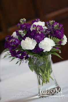 a vase filled with purple and white flowers