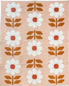 an orange and white quilt with flowers on it