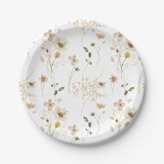 a white plate with floral designs on the front and side, against a white background