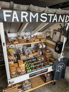 a farmers market stand with fresh produce and other items for sale on the shelves in front of it