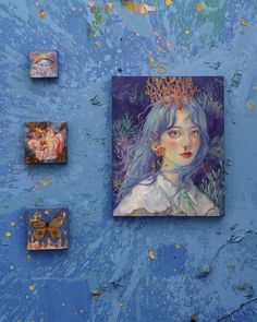 some paintings are hanging on the wall and there is a blue background with gold flecks