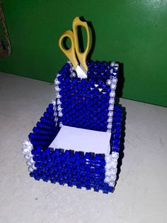 a pair of scissors sitting on top of a box made out of beer bottle caps