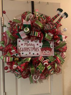 a christmas wreath with candy canes and decorations on the front door to welcome you