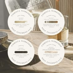 four labels on a wooden table next to a glass with a spoon and measuring cup