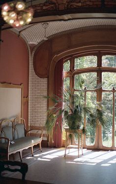 a living room filled with furniture and a large open window next to a chair in front of it