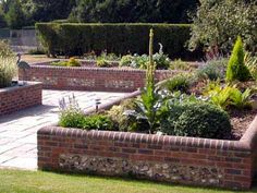 a brick garden bed in the middle of a yard