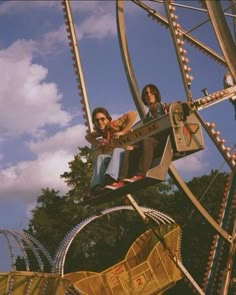 two people ride on a roller coaster at an amusement park