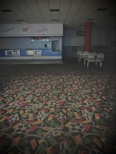 an empty room with chairs and carpet in it