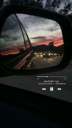 the rear view mirror of a car with cars in it at dusk and oncoming traffic