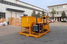 a large yellow machine sitting in the middle of a parking lot next to a building