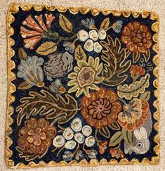 an old rug with flowers and leaves on it